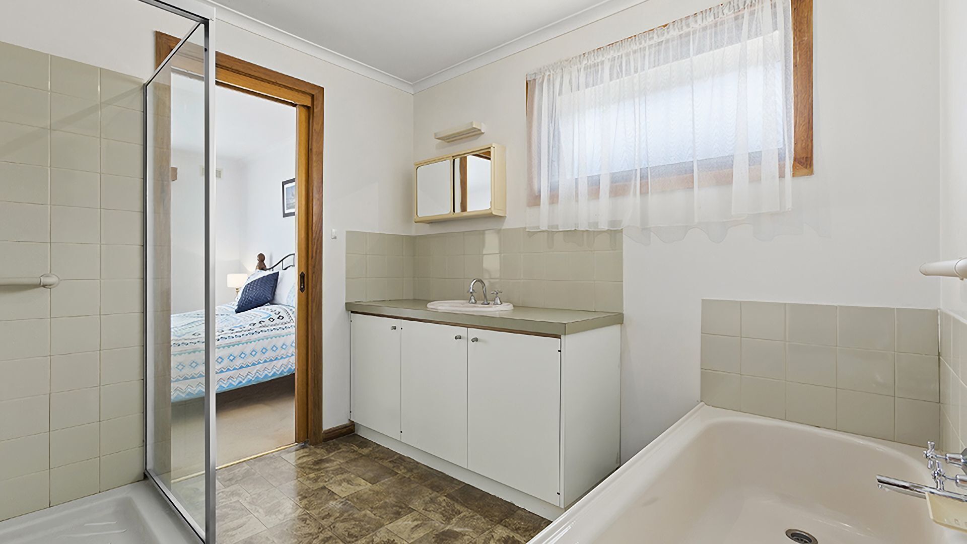Un baño con bañera, lavabo y espejo.