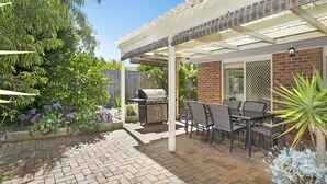 A patio with a grill, outdoor seating, and a brick pathway. - Private Hideaway - Point Lonsdale (POINT LONSDALE)