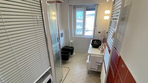 A compact bathroom with a washing machine, a sink, and a window. - Romantica Suite modern apartment in Verbania Intra (Verbania)