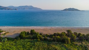 A beach with a clear view of the sea and distant mountains. - Ada Villa (Fethiye)