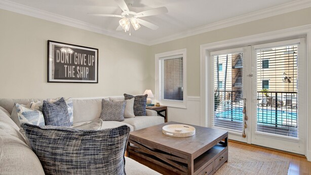A living room with a sofa, coffee table, and a framed motivational quote on the wall. - Great Family Condo with Pool Views! Pool Access (Tybee Island)
