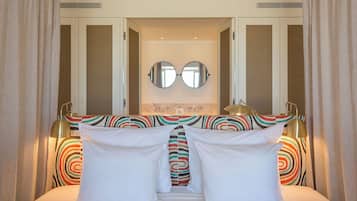 A hotel room with a bed, two bedside lamps, a mirror, and a window.