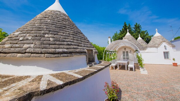 A traditional white building with a stone roof and a white dome structure.