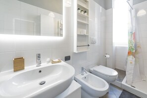 A modern bathroom with a large sink, bidet, and a shower curtain. - GuestHost - Zadar & Apartment on the Island! 100 m from the Istrie M5 stop! (Milano)