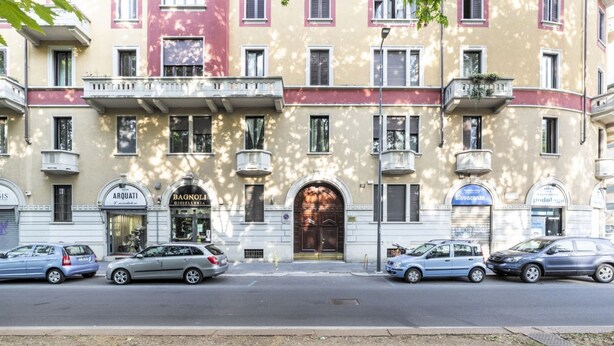 A multi-story building with a central entrance, several balconies, and parked cars on the street. - GuestHost - Zadar & Island APT! 100m from the Istria M5 stop! (Milano)