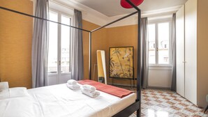 A four-poster bed with white linens and towels, a painting on the wall, and patterned floor tiles. - GuestHost - Zadar & Island APT! 100m from the Istria M5 stop! (Milano)
