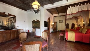 Une pièce de style traditionnel comprenant un coin repas, un canapé rouge et un lustre.
