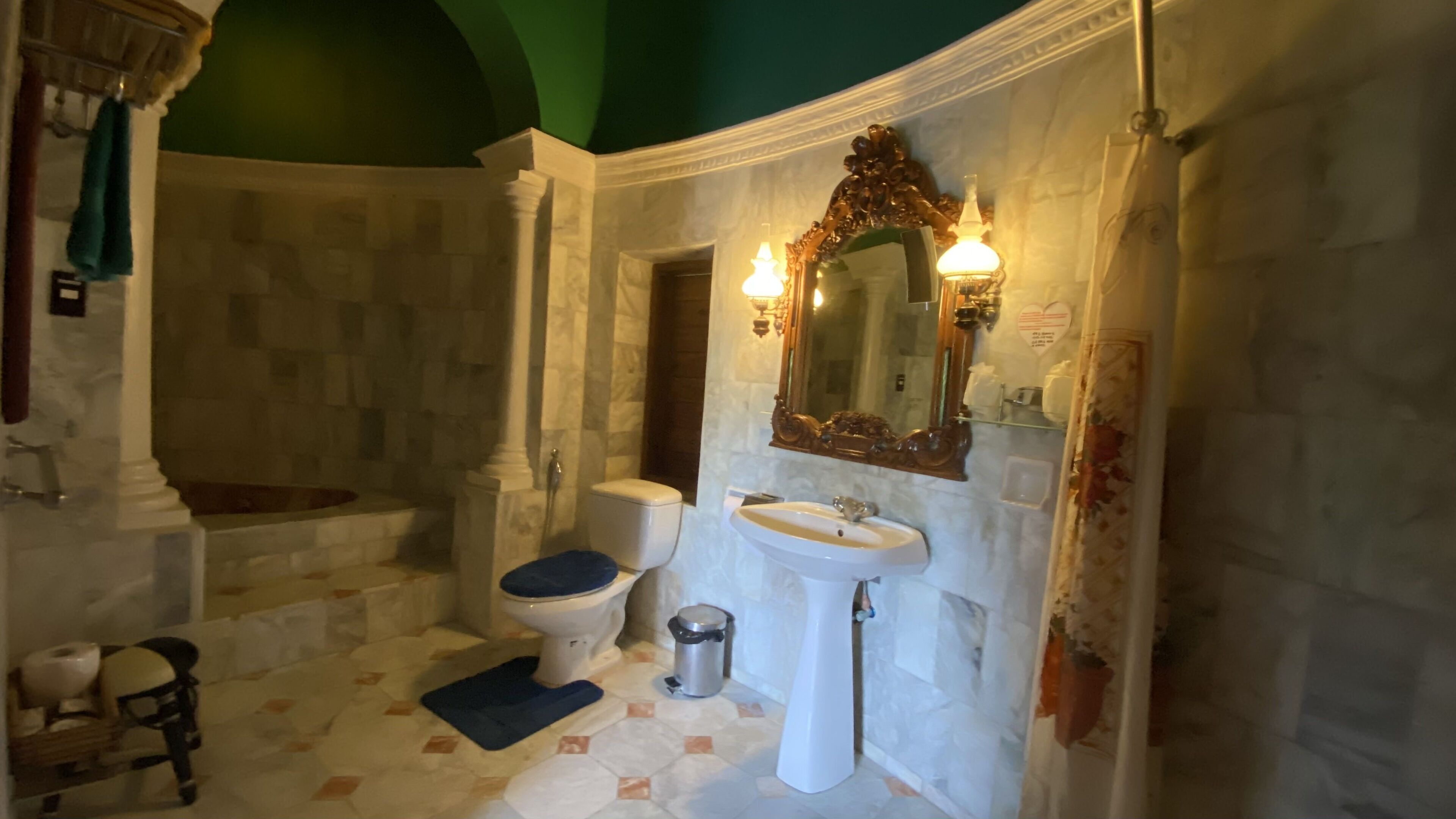 Un baño con bañera, inodoro, lavabo y espejo con luces.