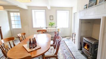 Un comedor con mesa de madera, sillas y chimenea.