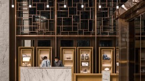 Una zona de recepción con mostradores de mármol y estanterías de madera que exhiben diversos objetos.