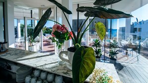 Cocina moderna con encimera de mármol, plantas en macetas y vistas a la terraza exterior.