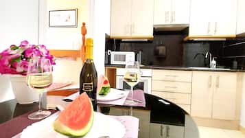 Een koelkast, een magnetron, een oven, kookgerei, borden en bestek