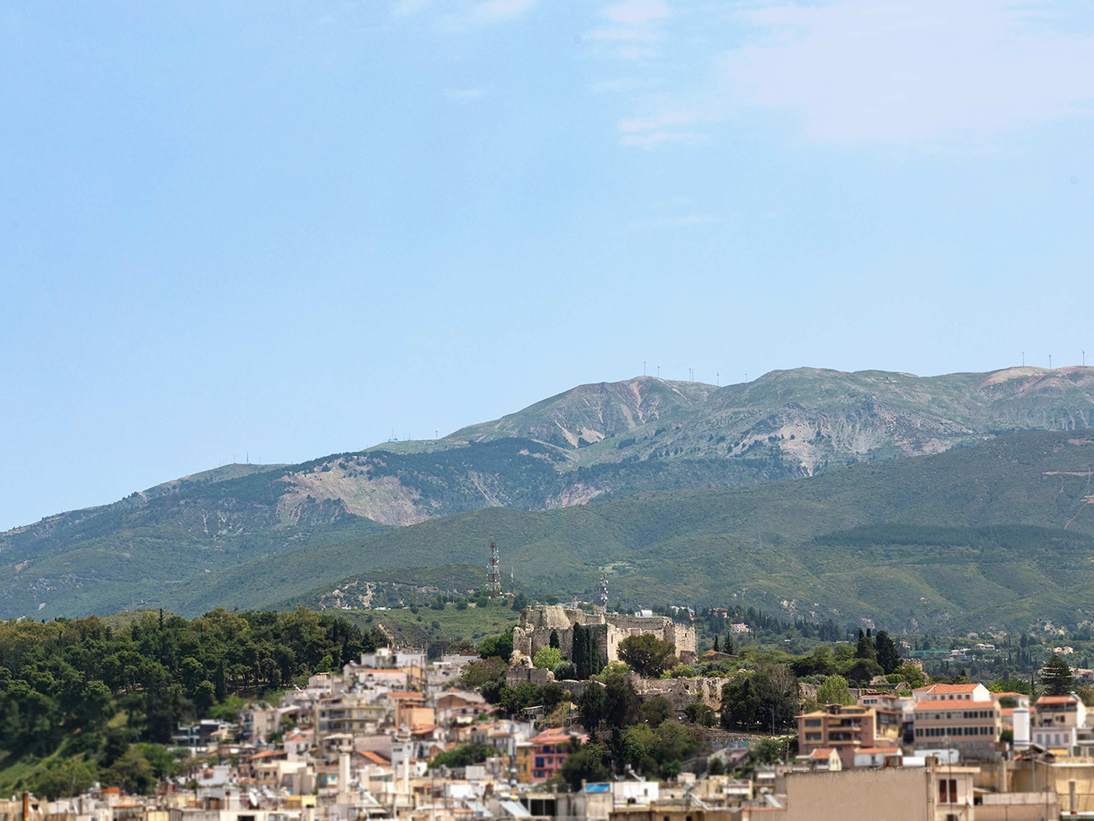 Un paisaje urbano con una colina destacada al fondo, que presenta una mezcla de edificaciones residenciales e históricas.
