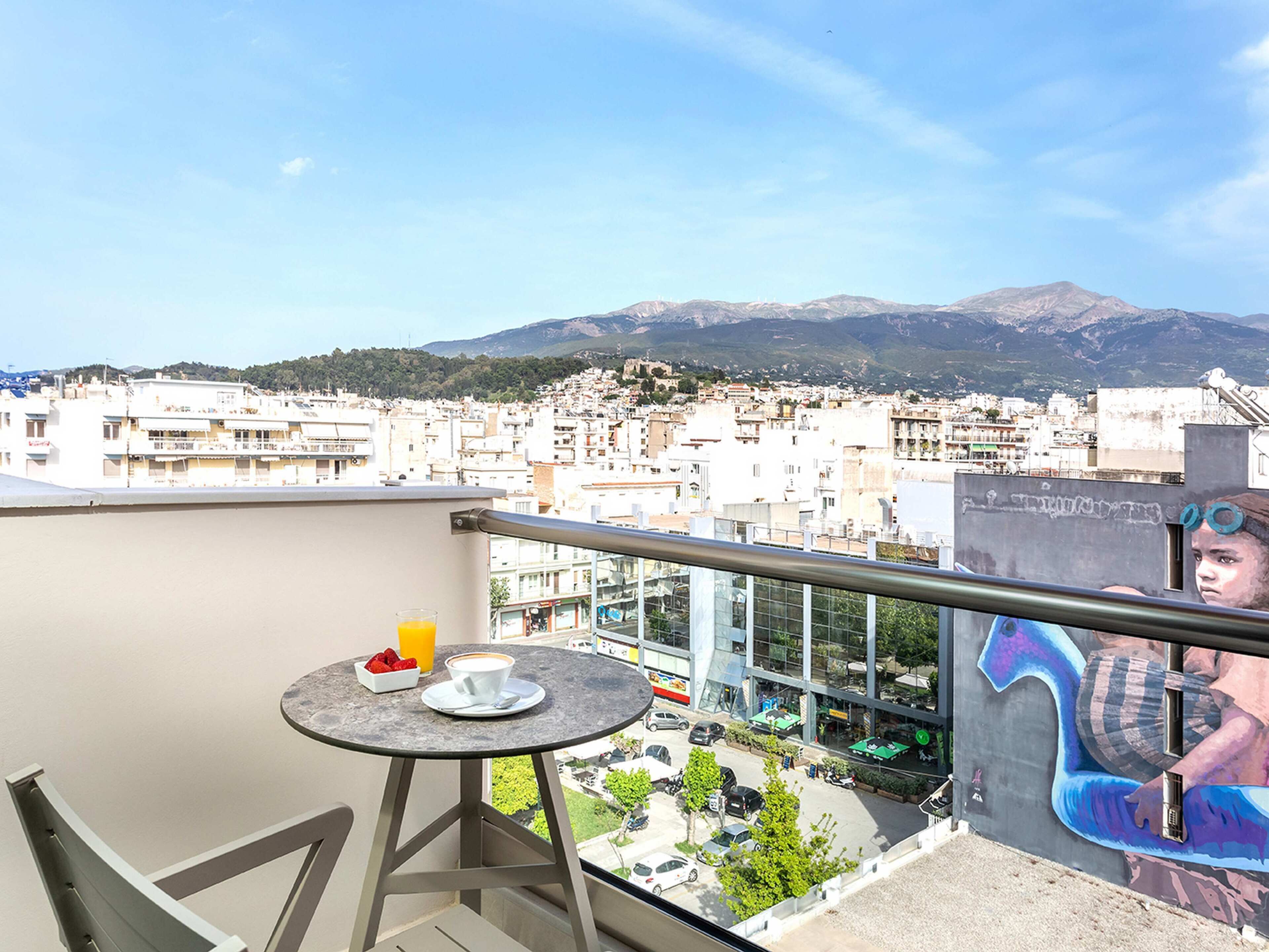A balcony with a table, a cup of coffee, and a glass of orange juice.