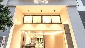 Un moderno edificio de hotel con varios balcones, una entrada de vidrio y un letrero que dice "DAYS CITY SUITES".