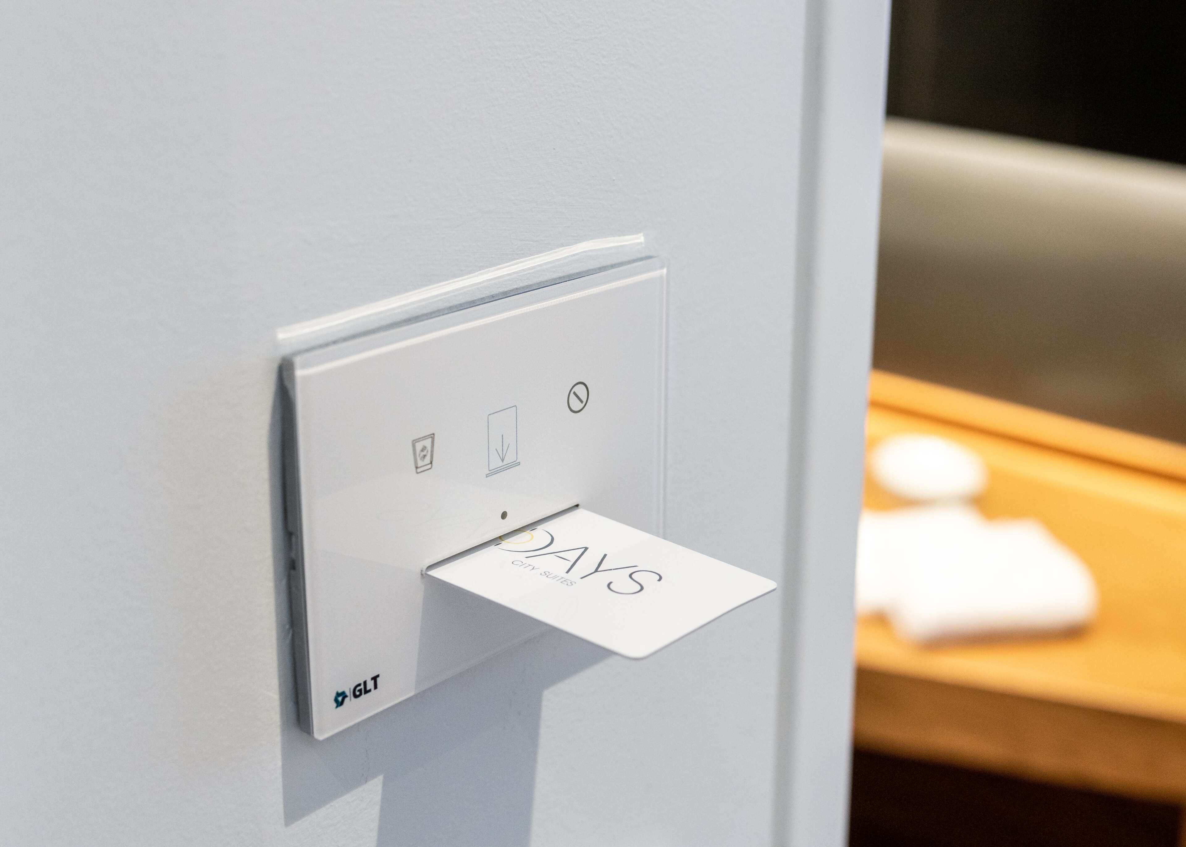 A modern light switch with a digital display and a small card holder.