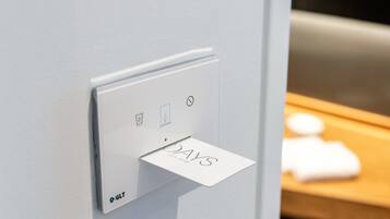 A modern light switch with a digital display and a small card holder.