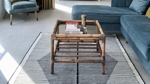 A modern living room with a bed, a blue sofa, a chair, and a coffee table.