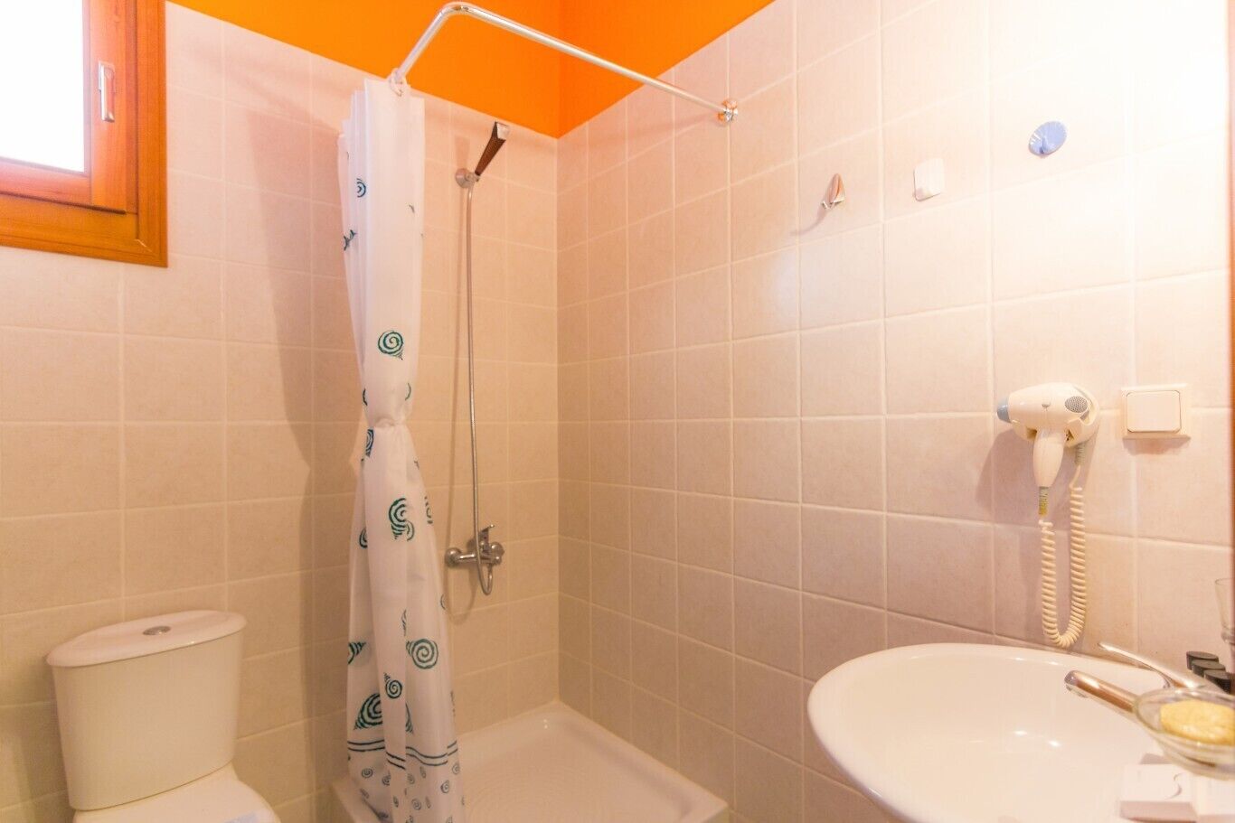 Une salle de bain avec douche, toilettes et lavabo.
