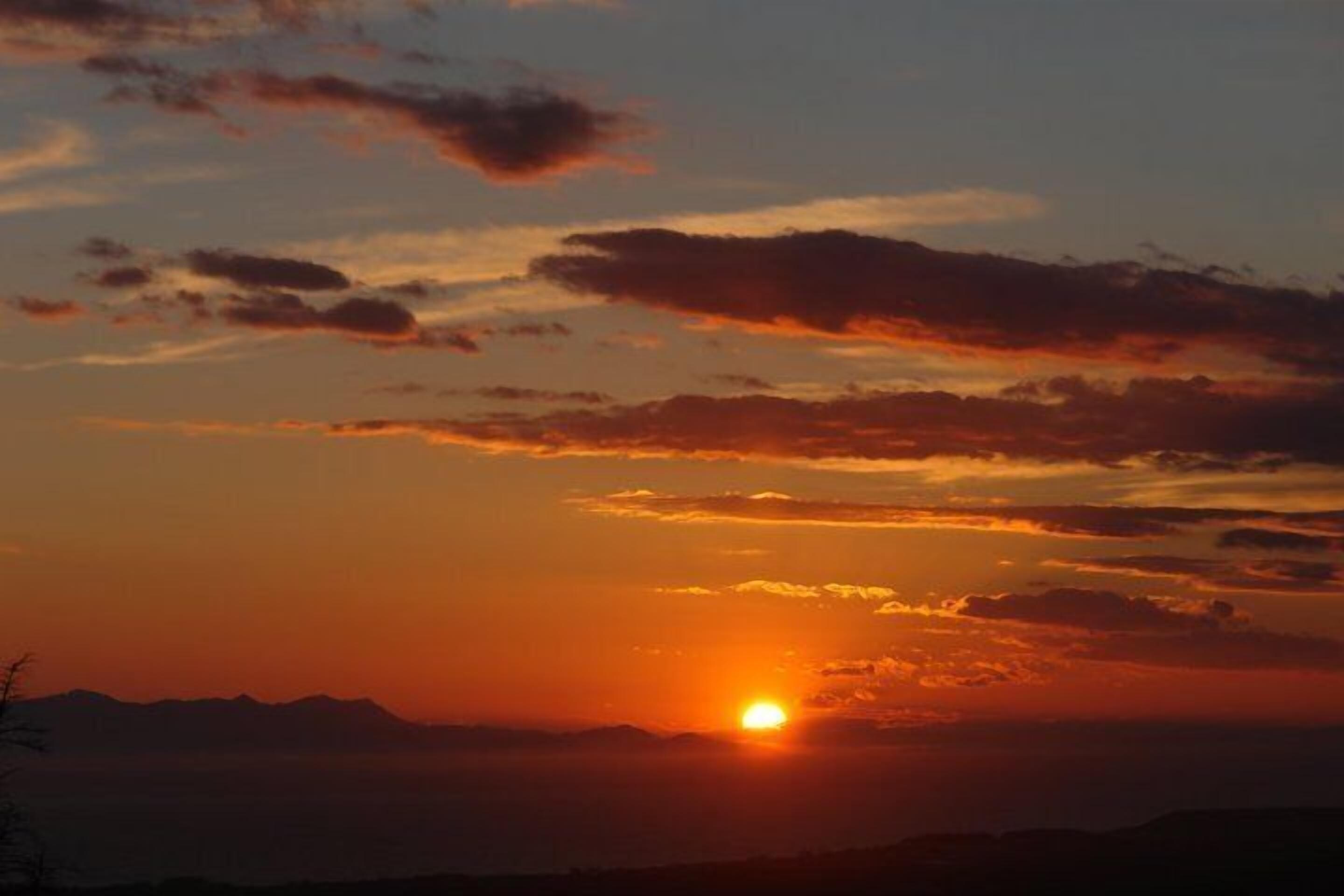 Un atardecer sobre un paisaje montañoso.
