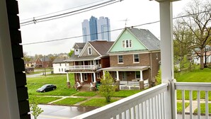 A wooden porch with a white railing overlooking a residential street. - The Maid of the Mist Villa-Yard &Parking (Niagara Falls)