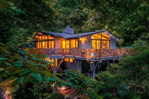 Une maison moderne dotée d’une terrasse, entourée d’une forêt dense.
