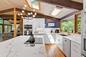 A modern kitchen with a central island, built-in appliances, and a skylight.