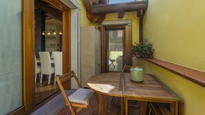 A wooden table with chairs in a sunlit room with yellow walls and a view of the outside. - New Deal - APT with Terrace & Jacuzzi (Palmanova)
