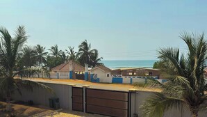 A residential area with a paved driveway, palm trees, and houses with blue and white exteriors. - A peaceful family home with brilliant sea views, set within private grounds. (Oshiyie)