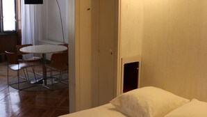 A hotel room with a bed, a small table, and chairs.