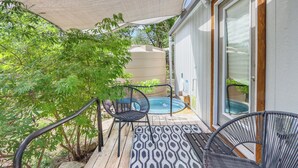 Eine Terrasse mit Pool, Gartenmöbeln und einem überdachten Bereich mit Sonnensegel.