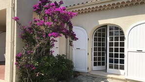A building with a stucco exterior, white doors, and a tiled roof.