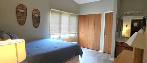 A bedroom with a bed, bedside tables, a wardrobe, and a window with blinds.