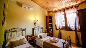 A room with two beds, wooden ceiling, a bookshelf, and a window with curtains. - Villa Ellea by pugliadamare (San Michele Salentino)