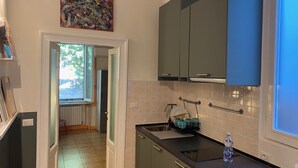 A modern kitchen with dark cabinets, a window, and a view of the outdoors.