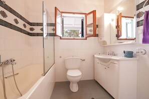 Une salle de bain avec une baignoire, des toilettes et un lavabo.