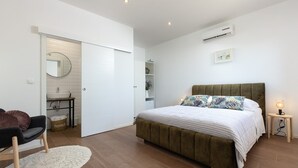A bedroom with a bed, bedside table, and a wardrobe.