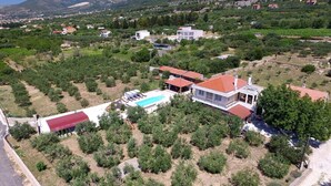 A residential area with houses, a swimming pool, and a mountainous backdrop.