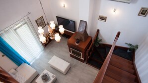 Ein modernes Wohnzimmer mit einer Couch, einem Couchtisch, einem Fernseher und einer Deckenleuchte.