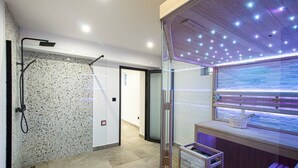 A modern bathroom with a spa area, including a shower, a bench, and a window with a view.