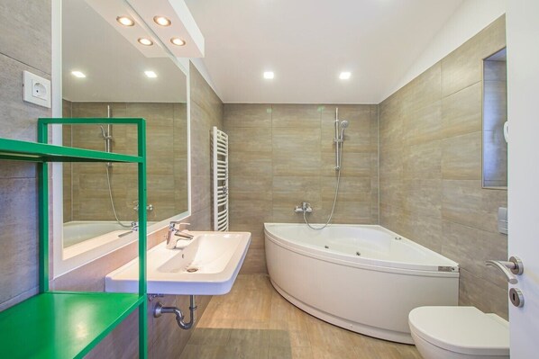 A modern bathroom with a freestanding bathtub, a sink, and a toilet.