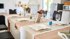 A dining table set with white plates, cutlery, and glasses, with a vase of flowers and a decorative candle holder. - Modern Villa Melli with a pool, Whirlpool and panoramic View (Vizinada)