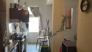 A kitchen with a stove, cabinets, and a dining area with chairs and a table.