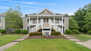 A two-story house with a front porch, a staircase, and a mailbox. - Salt & Light - 1st Floor 3BR unit in True Blue (Pawleys Island)
