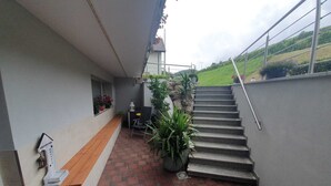A staircase leading to a balcony with a view of a green hillside. - Kaiserstuhl "auszeit " (Vogtsburg im Kaiserstuhl)