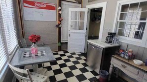 A kitchen with a black and white checkered floor, a table with chairs, a refrigerator, and a sink. -  Stay downtown within walking distance of restaurants, shopping, and breweries! (Bardstown)