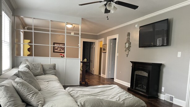 A living room with a sectional sofa, a fireplace, and a television mounted on the wall. -  Stay downtown within walking distance of restaurants, shopping, and breweries! (Bardstown)