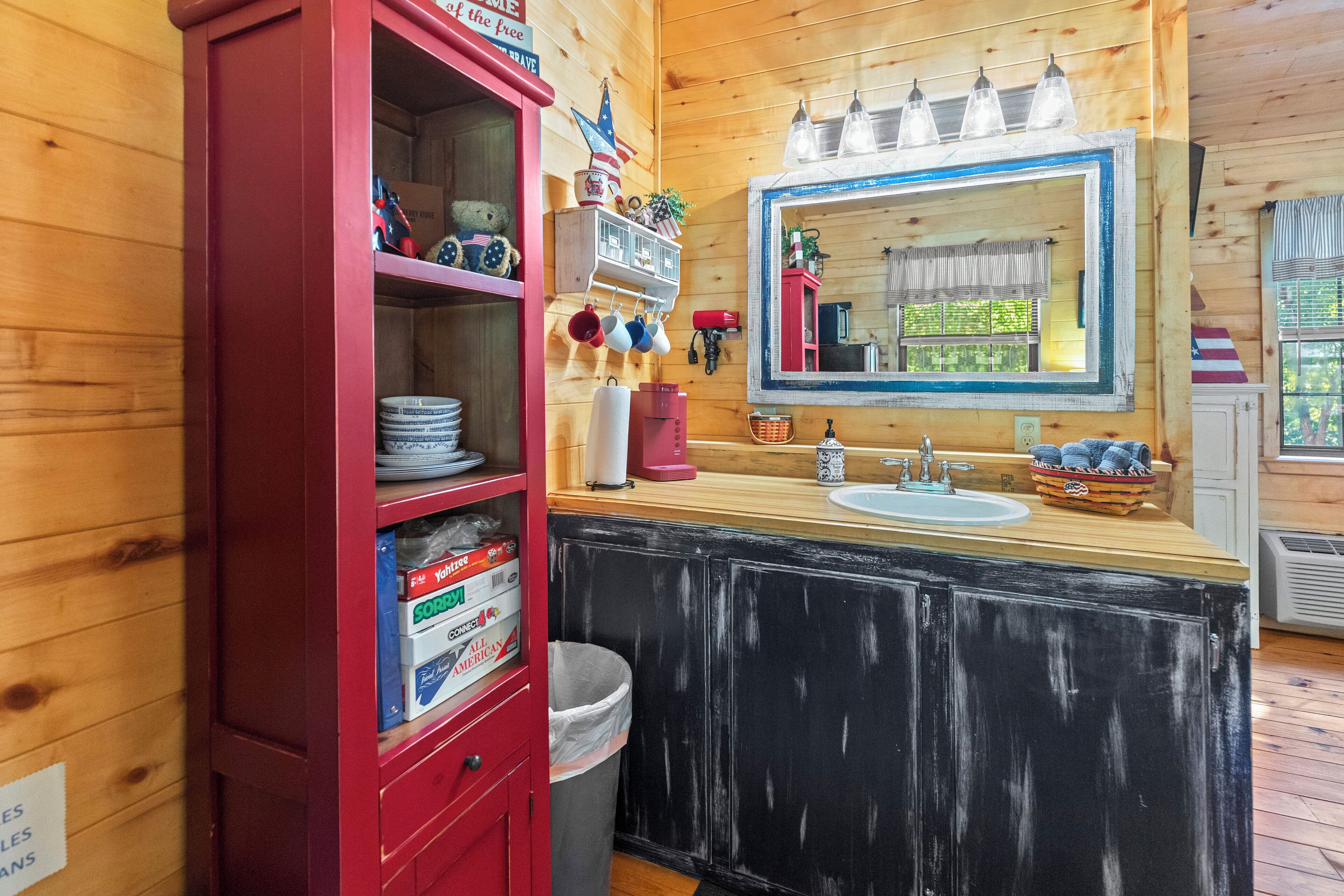 Une salle de bain de style rustique, avec des murs en bois, un meuble rouge, un lavabo et un miroir.