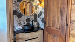 A bathroom with a wooden vanity, a round mirror, and a black sink. - Charming 3 Bedroom Alpine Apartment. Central location and with beautiful views (Samoëns)