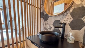 A bathroom with a black sink, a mirror, and a soap dispenser. - Charming 3 Bedroom Alpine Apartment. Central location and with beautiful views (Samoëns)